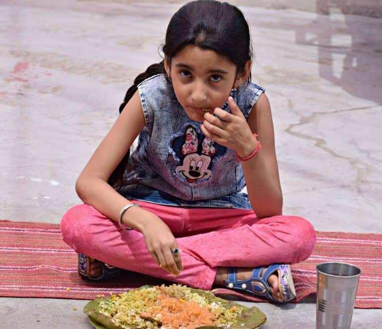 A child being fed during Annadaan