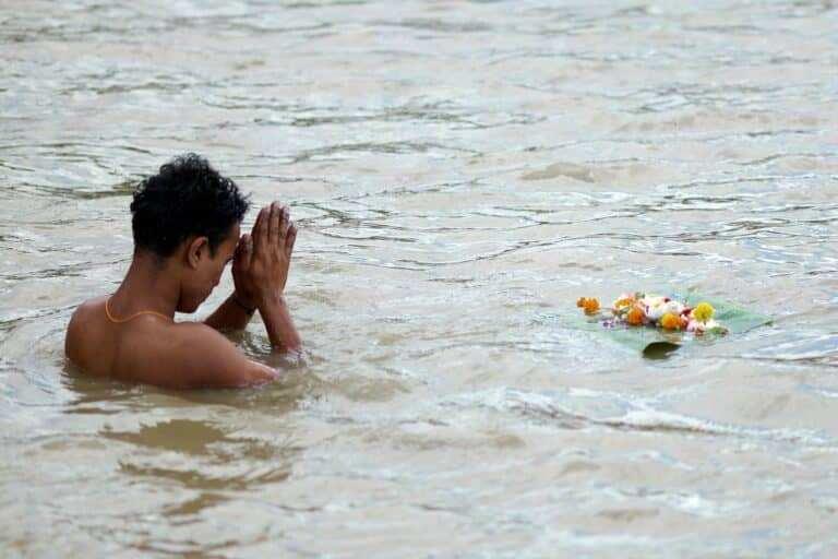 Priest performing rituals on the riverbank